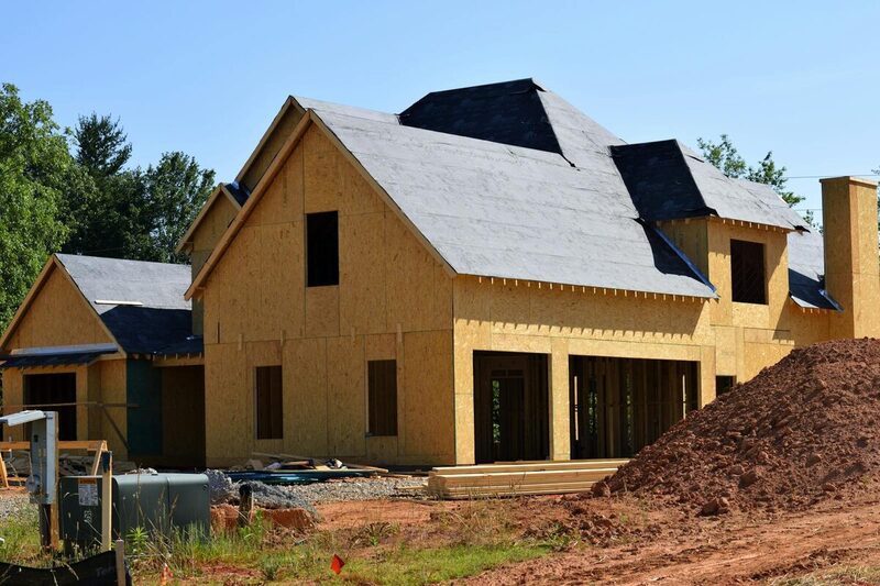 Residential house under construction with wood framing and roof sheathing