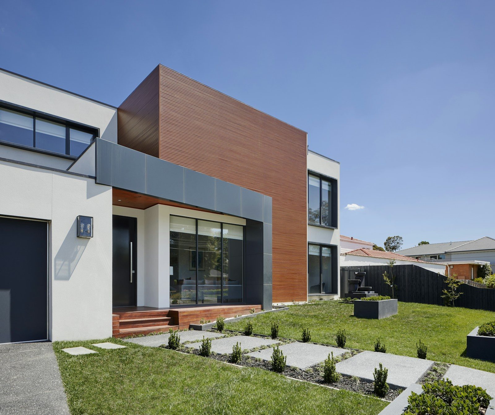 Modern home with wood-clad attached addition extending from main structure