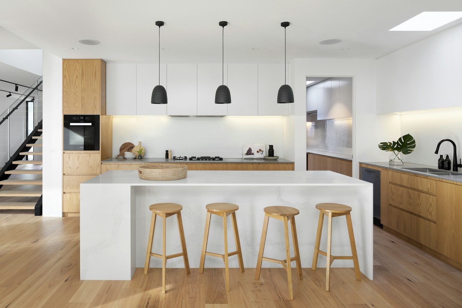 Modern remodeled kitchen with wood island, pendant lights, and contemporary finishes